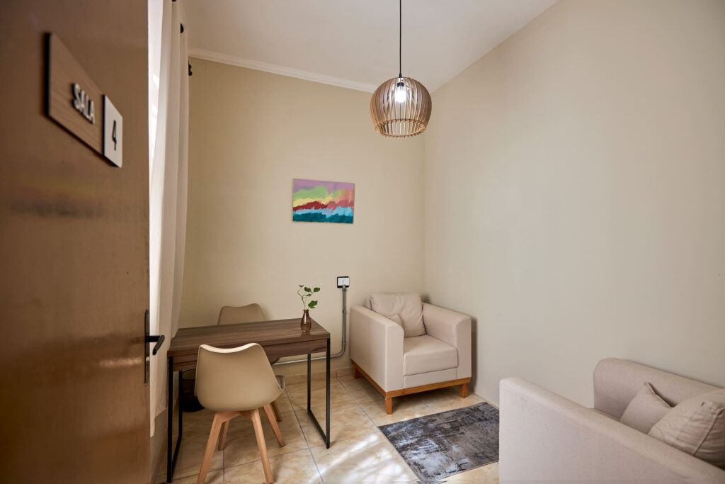 Vista da Sala 4, um dos nossos espaços para aluguel de sala para psicólogo em Campinas**, mostrando a mesa de trabalho e as poltronas.